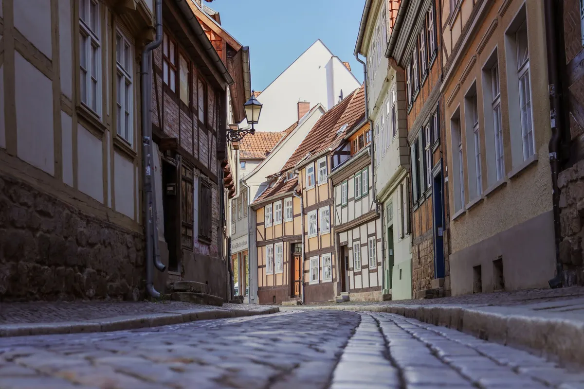Enge Kopfsteinpflastergasse in einer deutschen Altstadt mit Fachwerkhäusern, schmalen Hauseingängen und alter Straßenlaterne
